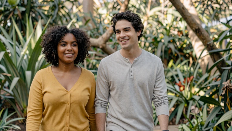 Neurodivergent couple walking together in a peaceful botanical garden, representing authentic neurodivergent love and relationships