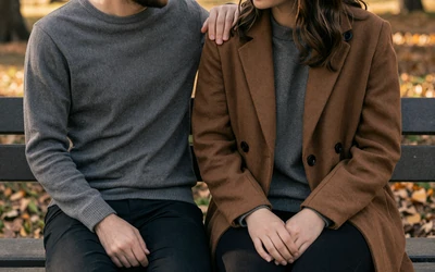 Couple supporting each other emotionally on a park bench, representing bipolar relationship communication